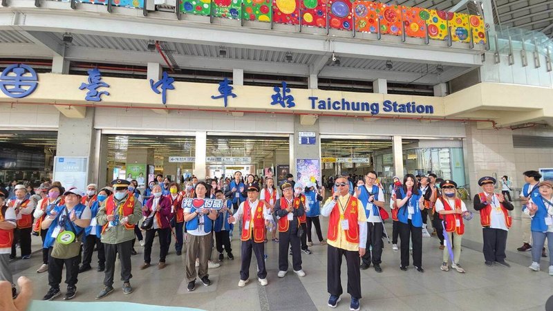 華山基金會28日與矽品精密工業公司合作，在志工陪伴下邀請30名獨居長輩到台鐵台中車站前快閃表演，盲眼爺爺魏春發（前）帶領大合唱「甘願」等多首歌曲，一圓上台表演的夢想。（矽品公司提供）中央社記者蘇木春傳真　115年3月28日