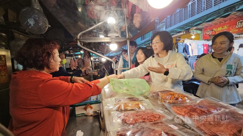 民進黨新北市長參選人蘇巧慧(右2)29日率多名黨籍議員參選人到市場掃街拜票,獲不少攤商路人歡迎。中央社記者王鴻國攝 115年3月29日
