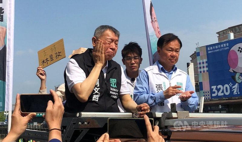 前台灣民眾黨主席柯文哲(前左)31日陪民眾黨嘉義市長參選人張啓楷(前右)車隊掃街拜票,由於天氣炎熱,行前2人還抹防曬乳液。中央社記者黃國芳攝 115年3月31日