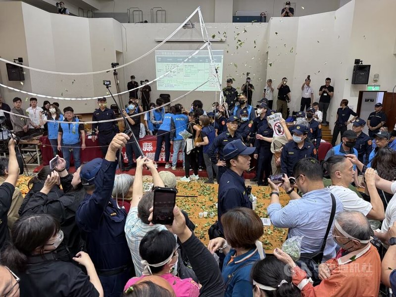 南投縣政府1日舉行「南投縣垃圾處理及再生能源中心第2階段環境影響評估範疇界定會議」第2次延續會議，會議一開始便發生衝突，民眾撒紙錢及茶葉抗議、大喊停止會議。中央社記者蕭博陽攝　115年4月1日