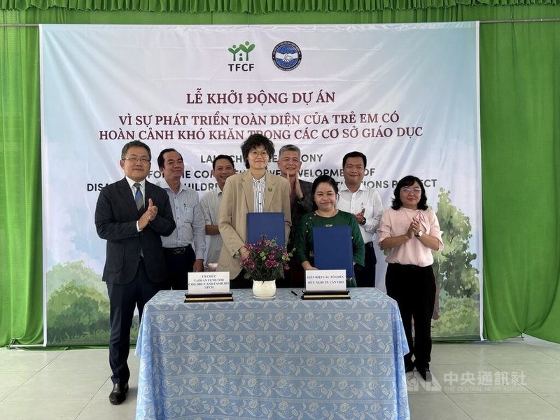 芹苴市越南友好組織主席黎氏成江（前右）與家扶基金會越南代表黃雅歌（前左）3月31日於新祿島上國小簽署合作備忘錄。駐越南代表劉世忠（後排左1）、胡志明市台商會長曾潮星（後排右3）等人見證。中央社記者曾婷瑄新祿島攝　115年4月2日