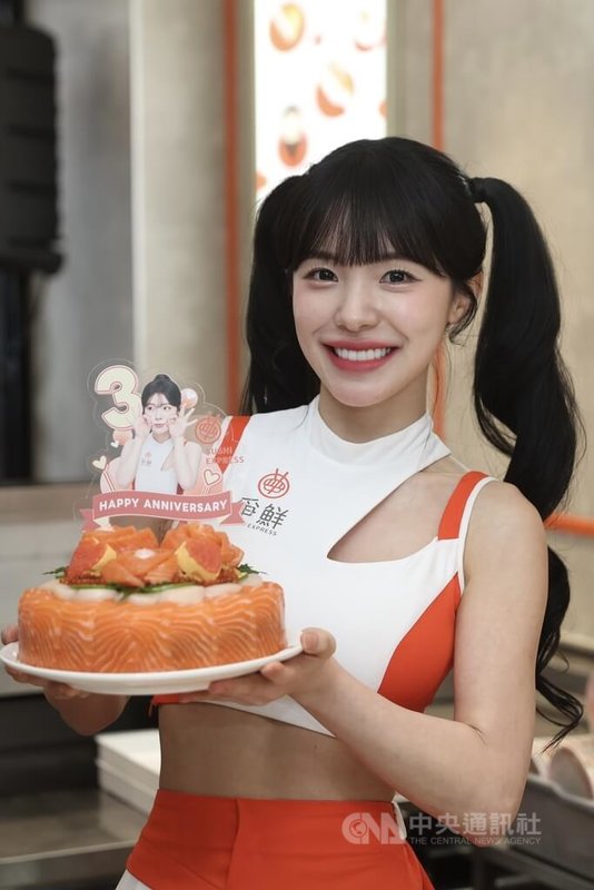韓籍啦啦隊員李多慧（圖）2日下午在台北出席迴轉壽司品牌活動，李多慧手持鮭魚壽司蛋糕合影。中央社記者吳家昇攝 115年4月2日
