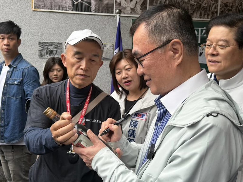 國民黨新北市長參選人李四川（前右）3日前往位於新店的胡璉將軍故居參訪，他指出，胡璉曾於對日抗戰、金門防衛戰中立下戰功，故居具備深厚歷史意義。圖為李四川在紀念酒上簽名。（李四川辦公室提供）中央社記者黃旭昇傳真　115年4月3日