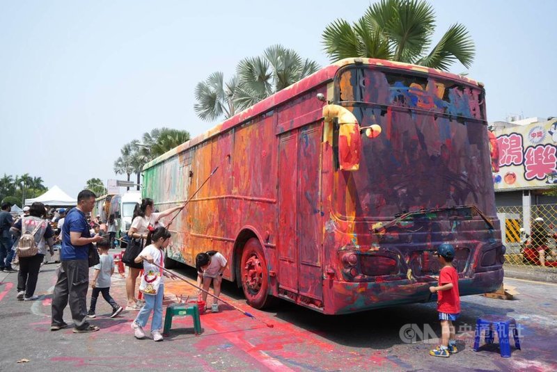 屏東縣政府「包圍縣府　孩子作主」封自由路一向，放置3輛公車讓孩子運用水彩與各式工具，在車體與地面自由創作，將公共空間轉化為流動畫布。中央社記者黃郁菁攝 115年4月3日