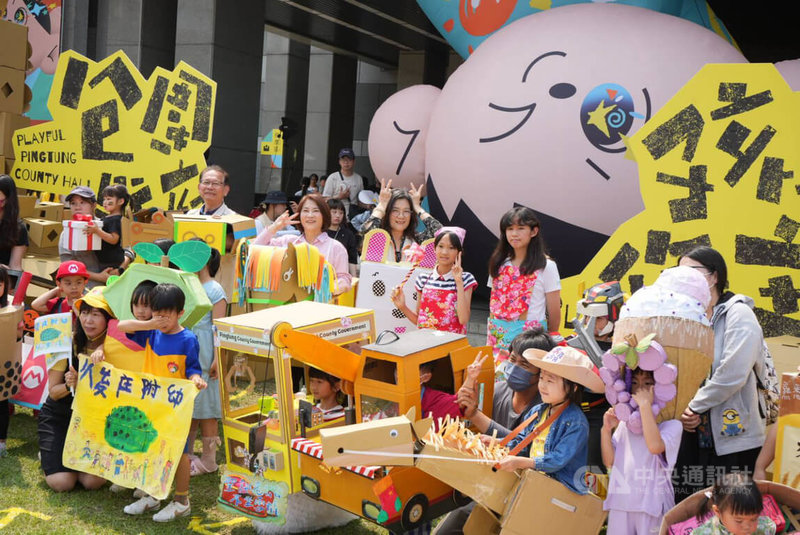 屏東縣政府「包圍縣府　孩子作主」3日登場，以孩子創意紙箱造型走秀開場，屏東縣長周春米（2排右6）及副縣長鄞鳳蘭（2排右5）也配合穿上造型紙箱。中央社記者黃郁菁攝 115年4月3日