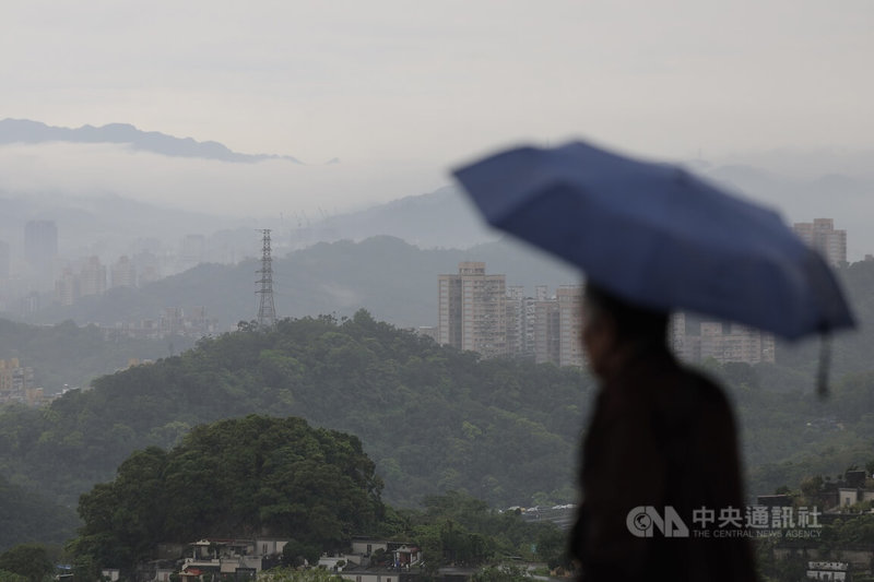 氣象專家吳德榮表示,3日清晨中部以北將有雨,白天後各地轉多雲時晴的天氣型態,溫度上「熱如夏」,各地高溫都可達到攝氏30度以上。圖為台北市文山區早上仍下著雨,民眾撐傘準備掃墓。中央社記者翁睿坤攝 115年4月3日