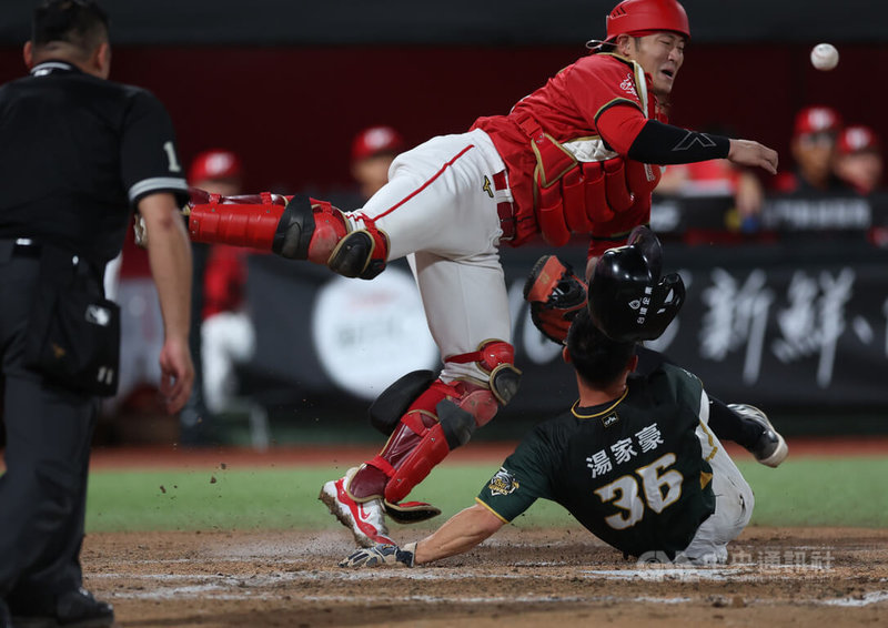 中華職棒台鋼雄鷹隊隊4日作客交手味全龍隊，雄鷹湯家豪（綠衣）7局上從二壘衝回本壘得分時，與龍隊捕手蔣少宏（紅衣）撞在一起，蔣少宏未能接住球，讓雄鷹再添分。中央社記者張新偉攝　115年4月4日