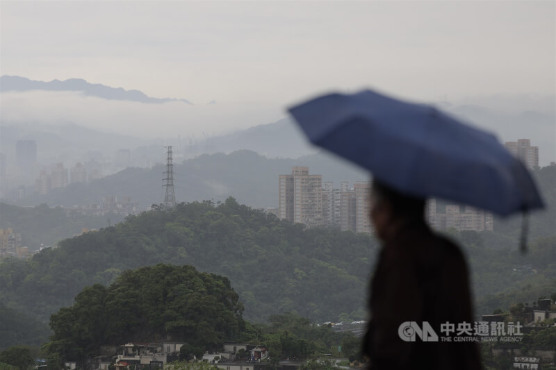圖為台北市文山區下著雨，民眾撐傘準備掃墓。（中央社檔案照片）