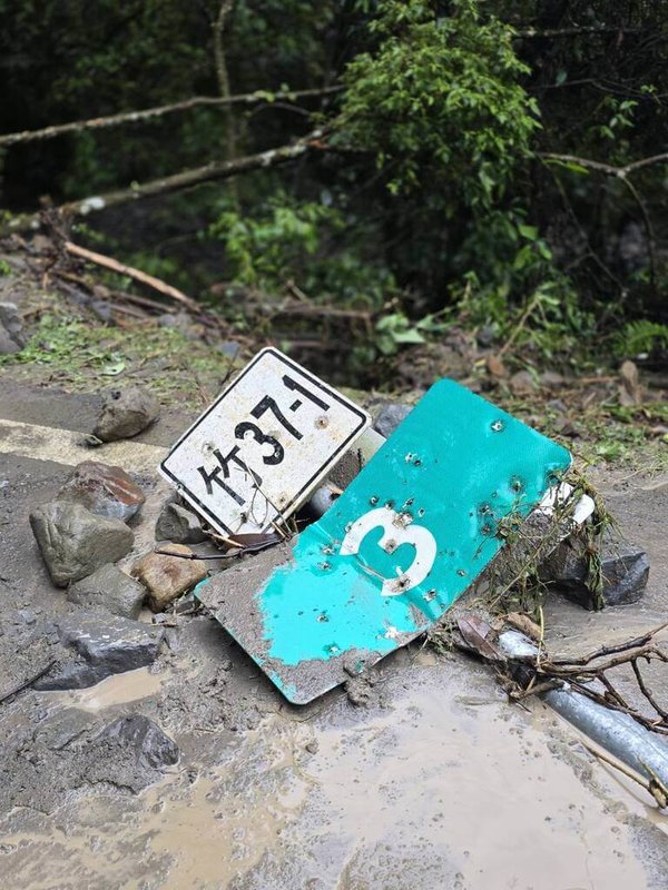 新竹縣北埔鄉通往苗栗縣南庄鄉的竹37-1線道路4日受雨勢影響，落石崩塌、路面泥濘，路旁標示牌毀損傾倒。（北埔鄉公所提供）中央社記者魯鋼駿傳真　115年4月4日