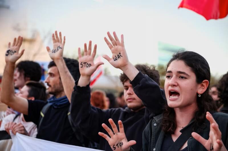 特拉維夫4日街頭集會民眾高舉雙手反對伊朗戰爭。（路透社）