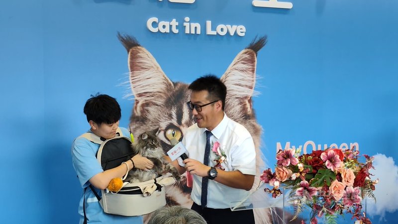 愛貓一生董事長、隆順漁業集團總經理王志遠(右)日前出席「愛貓工廠」開幕典禮,帶著愛貓亮相並與其互動。中央社記者何秀玲攝 115年4月5日