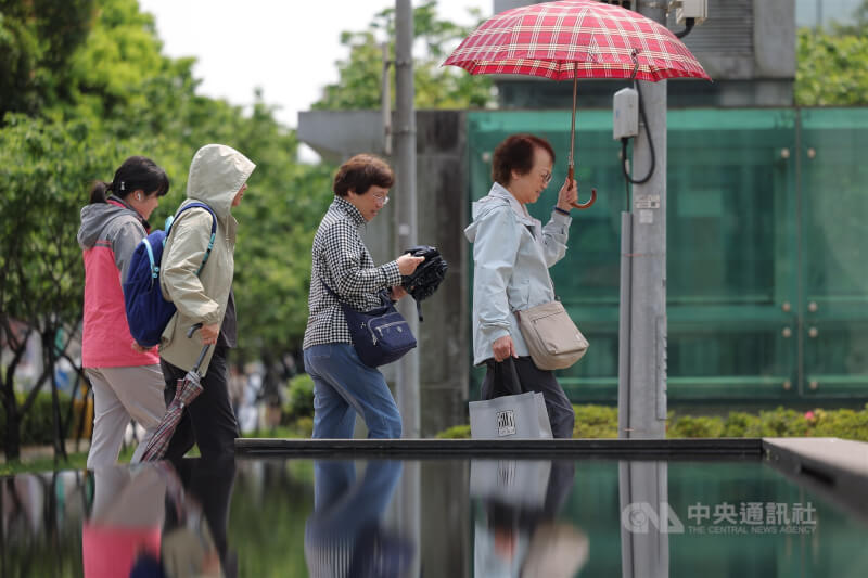 圖為北市南港區民眾撐傘遮陽。（中央社檔案照片）