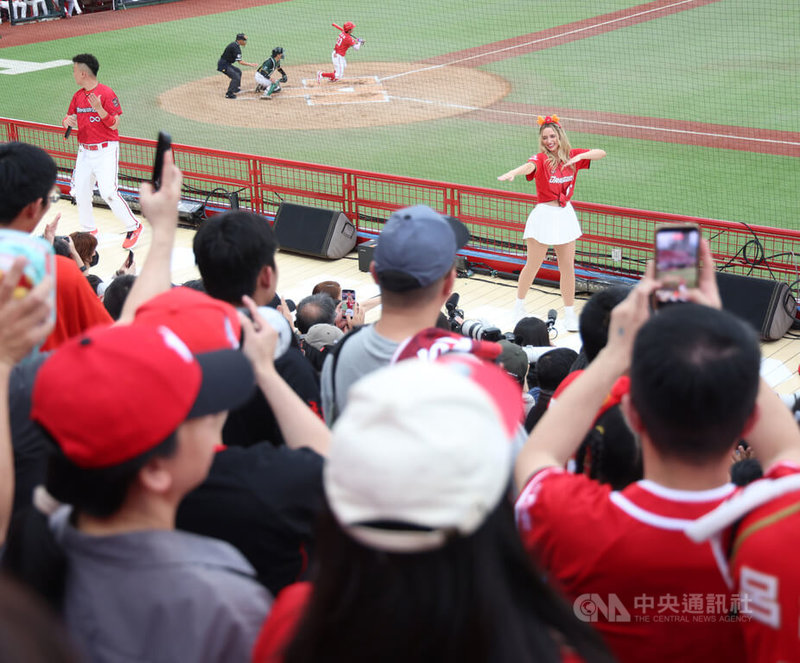 中華職棒味全龍隊5日邀請台美混血好手費柴德的太太韓納（Hanna Fairchild）（後右）到天母球場擔任開球嘉賓兼啦啦隊，韓納開球後走上看台與應援團隊一起帶動氣氛，吸引球迷目光。中央社記者張新偉攝　115年4月5日