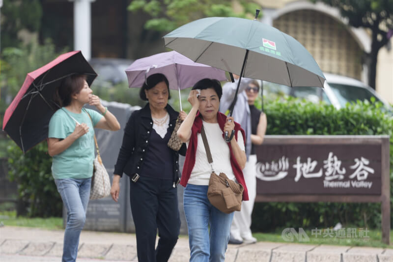 圖為4日遊客在台北市北投區撐傘遮雨。（中央社檔案照片）