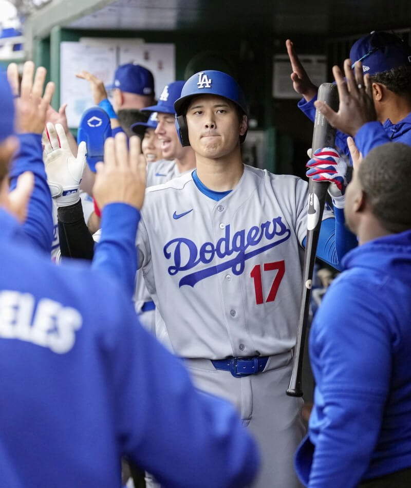 大谷翔平5日在道奇與國民之戰第8局擊出致勝高飛犧牲打，回到休息區與隊友擊掌慶祝。（共同社）