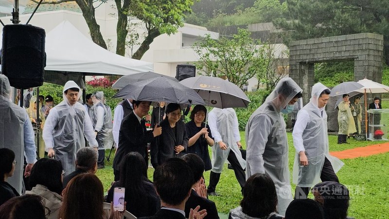 總統賴清德（左2）7日在新北市金山區金寶山墓園出席「鄭南榕殉道37週年追思紀念會」，與鄭南榕遺孀葉菊蘭（左3）一同撐傘進入會場。中央社記者王鴻國攝　115年4月7日