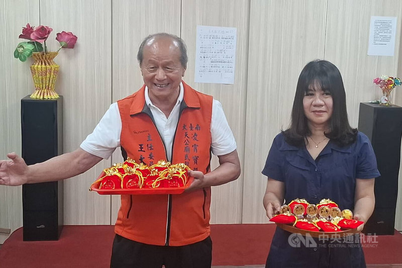 台南市永康區凌霄寶殿武龍宮獲總統賴清德贈匾「保境佑民」，武龍宮主委王大明（左）8日展示廟方製作的限量紀念幣，將於10日贈送給參與揭匾活動民眾。中央社記者楊思瑞攝　115年4月8日