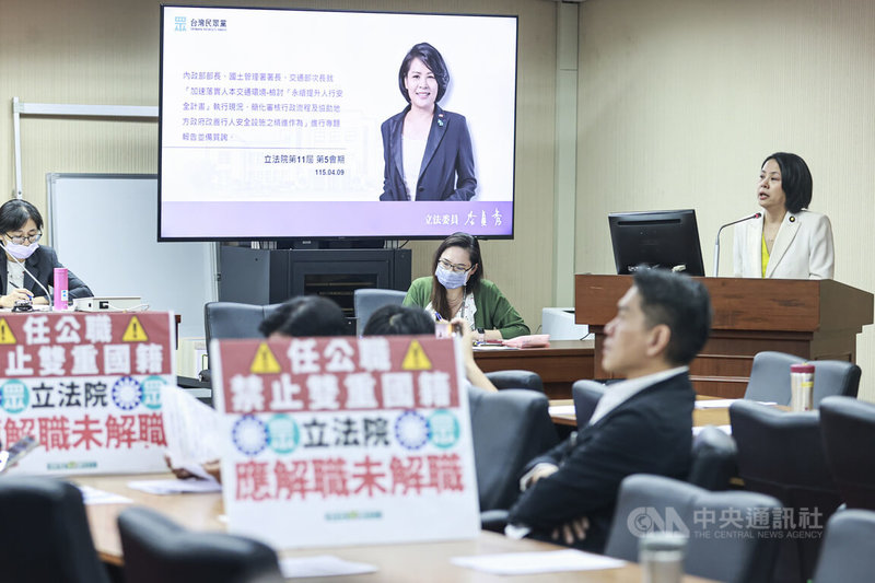 民眾黨立委李貞秀(右)9日在立法院內政委員會質詢,內政部長劉世芳不予回應,民進黨立委在台下擺放寫有「任公職禁止雙重國籍」的字卡表達抗議,讓李貞秀再度上演質詢獨白秀。中央社記者鄭清元攝 115年4月9日