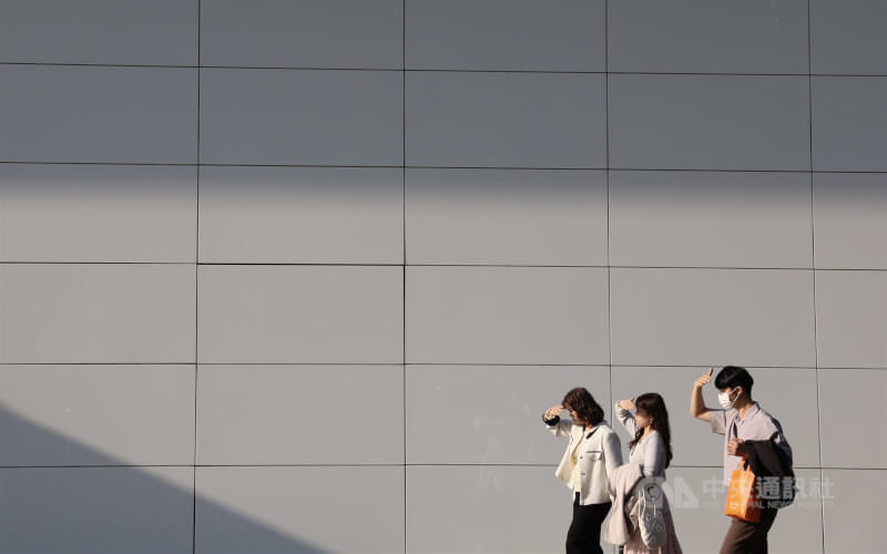 圖為台北信義商圈午後，路上民眾舉手遮擋陽光。（中央社檔案照片）