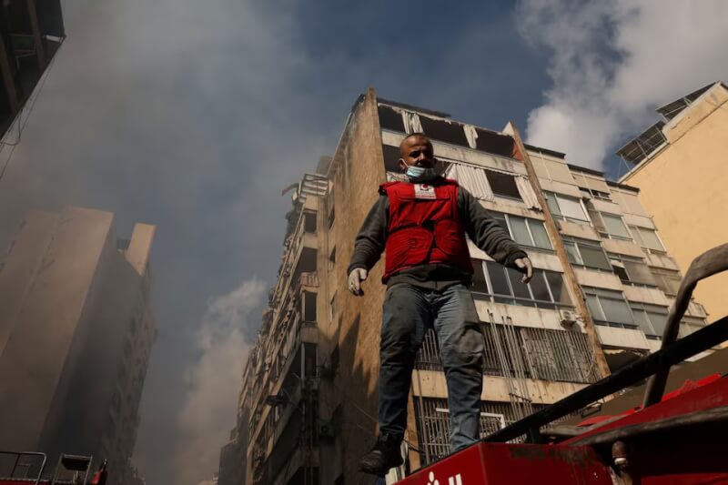 圖為1名搜救人員在黎巴嫩首都貝魯特遭以色列轟炸的住宅區展開救援。（路透社）