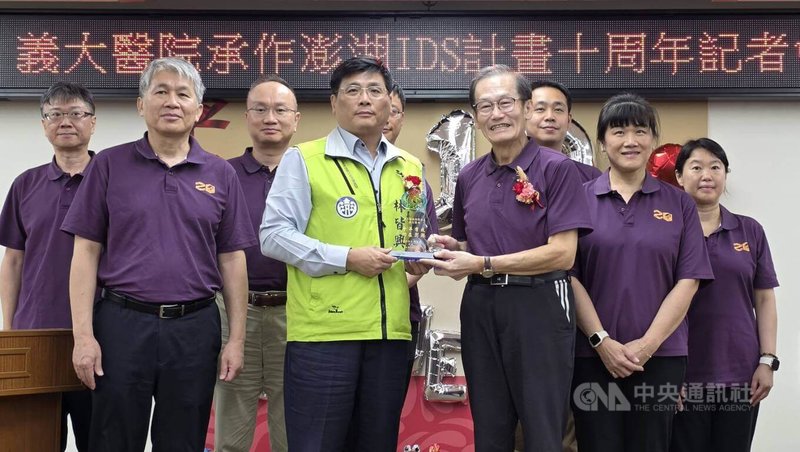 澎湖縣政府與義大醫院10日舉辦「義大醫院承作澎湖IDS計畫10週年」記者會,副縣長林皆興(前左2)代表縣長陳光復致贈10週年紀念牌給義大醫院院長杜元坤(前左3),義大十年如一日守護離島地區居民健康。中央社 115年4月10日