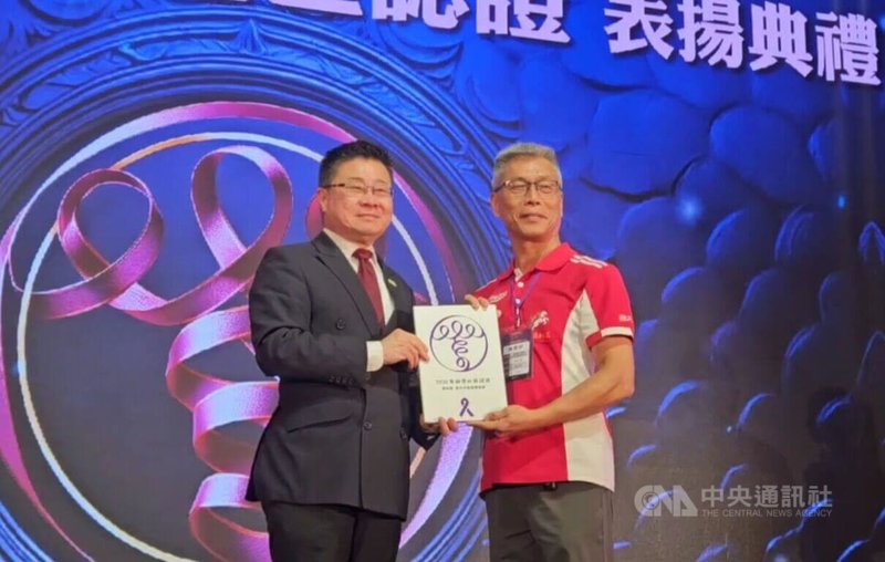 衛福部次長呂建德（左）11日出席第2屆紫絲帶社區認證表揚典禮，頒發認證證書給位於雲林縣斗南鎮的新光社區發展協會理事長陳聰明（右）。中央社記者陳婕翎攝　115年4月11日