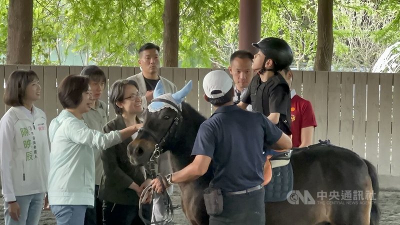 副總統蕭美琴（前左2）、民進黨立委何欣純（前左）11日南下台中走訪神岡區一處馬場，為腦麻兒阿戟（黑帽者）加油打氣，也了解適應性馬術推動兒童早療及身心支持等議題。中央社記者趙麗妍攝　115年4月11日