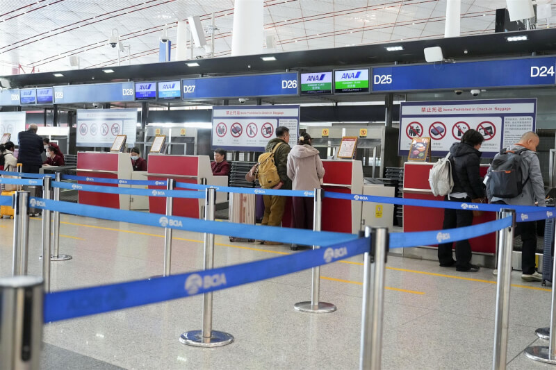 圖為中國北京機場2月飛往日本航班的報到櫃台人煙稀少。（共同社）