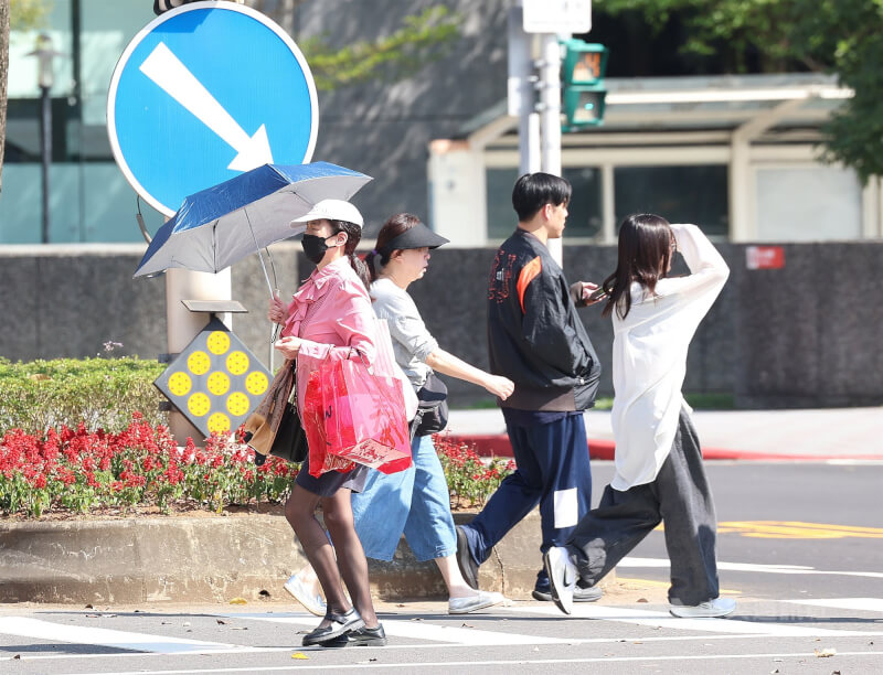 圖為台北市松山區民眾撐傘遮擋陽光。（中央社檔案照片）