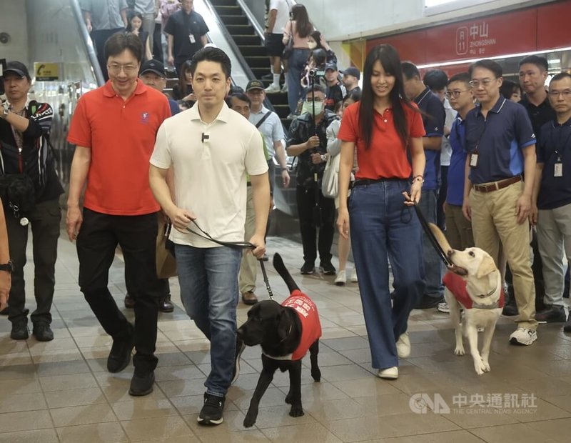 台北市長蔣萬安(白衣者)響應2026國際寵物日「狗狗春遊趣」活動,11日下午親自牽著導盲犬,從捷運中山站搭乘「狗狗友善列車」,與民眾同樂。中央社記者張皓安攝 115年4月11日