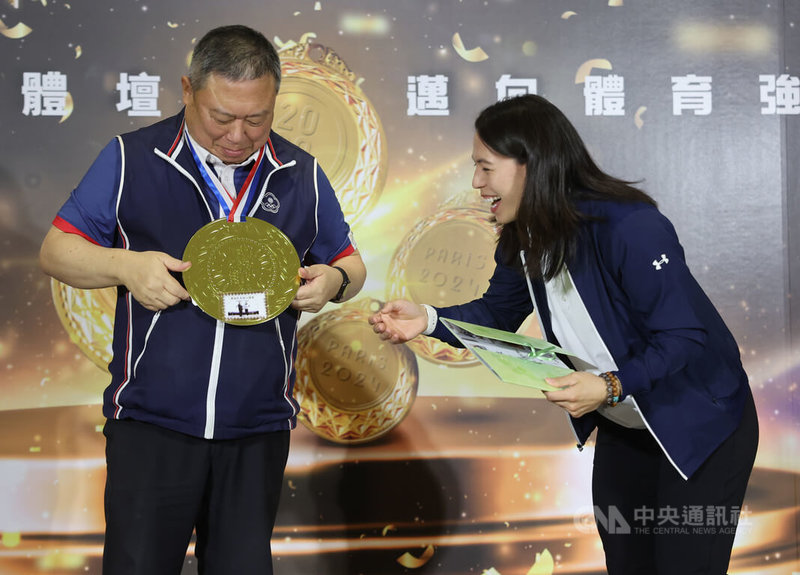 宏道基金會13日上午在台北舉行記者會頒發東京奧運、巴黎奧運奪牌選手獎金,女子舉重好手郭婞淳(右)出席領獎,並致贈宏道基金會董事長林鴻道(左)一面大獎牌,兩人互動熱絡。中央社記者趙世勳攝 115年4月13日