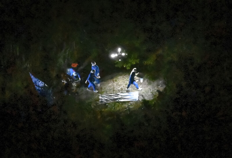 京都府警方13日晚間在南丹市山區發現一具身分不明的遺體，調查人員進行勘查。（共同社）