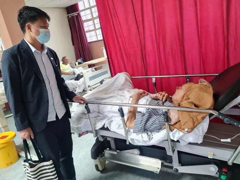 僑務秘書李永盛（左）代表僑務委員會前往探視接受清創的76歲獨居台僑（右），關心其病情與照護情形，展現政府對海外僑胞的關懷與支持。（豪登省台僑警友會會長尤向光提供）中央社記者李依璇傳真　115年4月14日