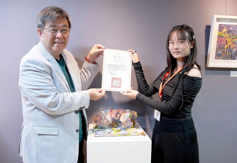 華梵大學舉辦全國高中職插畫A4秀，南大附中學生林品汝（右）以會動的立體童話書榮獲特優獎，由華梵大學校長李天任（左）頒獎表揚。（華梵提供）中央社記者許秩維傳真　115年4月14日