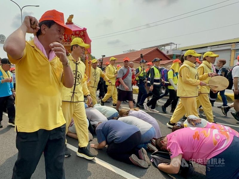 苗栗通霄白沙屯拱天宮媽祖徒步前往北港朝天宮進香，15日從彰化縣大村鄉起駕，沿台1線南下，許多民眾跪趴在地等待鑽轎底祈福。中央社記者鄭維真攝　115年4月15日