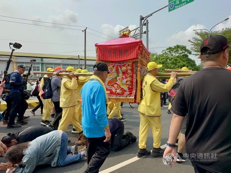 苗栗通霄白沙屯拱天宮媽祖徒步前往北港朝天宮進香，15日清晨5時從彰化縣大村鄉起駕，一路南下，途中不少民眾鑽轎底，祈求平安順遂。中央社記者鄭維真攝　115年4月15日