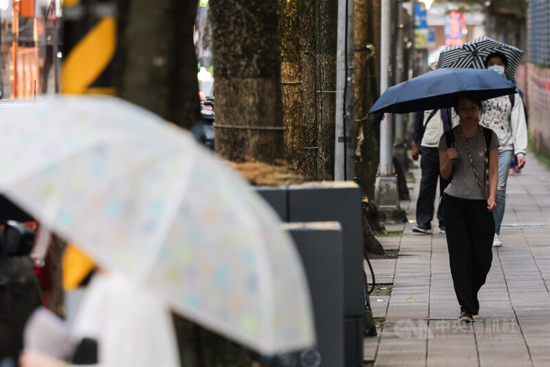 圖為台北市內湖區出現雨勢，街頭民眾撐起雨傘。（中央社檔案照片）