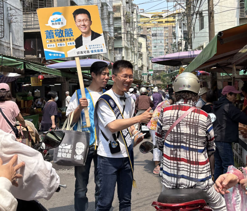 圖為14日蕭敬嚴（中）在汐止金龍市場拜票。（中央社檔案照片）
