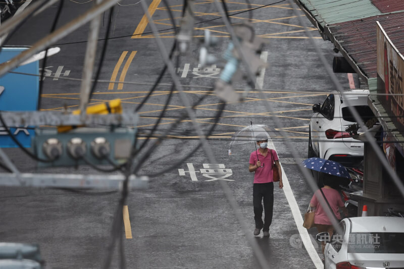 圖為新北市板橋區18日下午出現陣雨情形，民眾撐傘外出。中央社記者趙世勳攝 115年4月18日