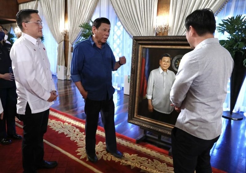 寫實派人物畫家殷帕斯（Jun Impas，右）2022年6月進入菲律賓總統府，向時任總統杜特蒂（左2）交付官方肖像。（殷帕斯提供）中央社記者林行健宿霧市攝傳真　115年4月19日