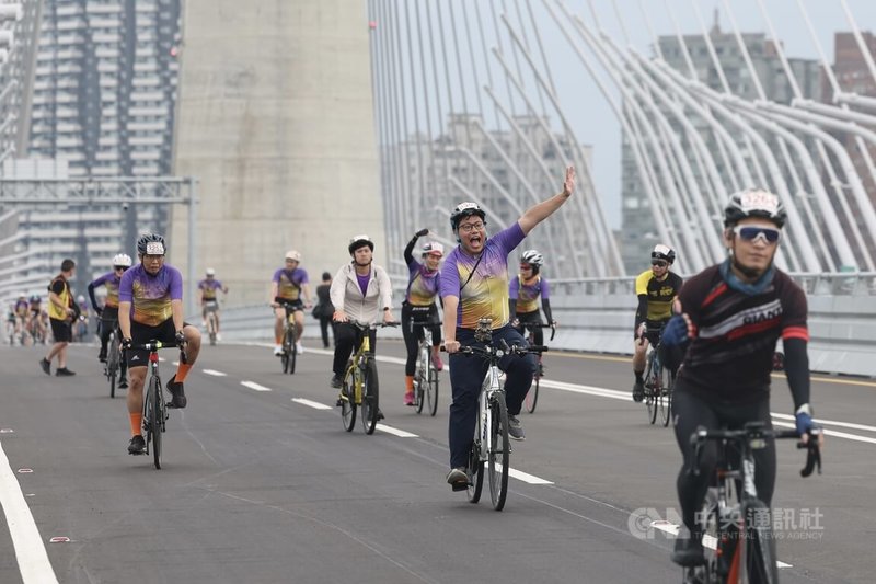 為迎接淡江大橋正式通車，交通部與新北市規畫通車前系列活動，19日舉辦自行車活動，自行車騎士搶先騎上淡江大橋，看到鏡頭開心揮手。中央社記者吳家昇攝 115年4月19日
