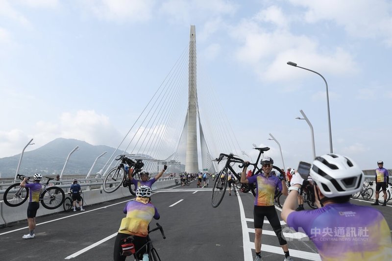 為迎接淡江大橋正式通車，交通部與新北市規畫通車前系列活動，19日舉辦自行車活動，自行車騎士搶先騎上淡江大橋，與淡水新地標合影留念。中央社記者吳家昇攝 115年4月19日