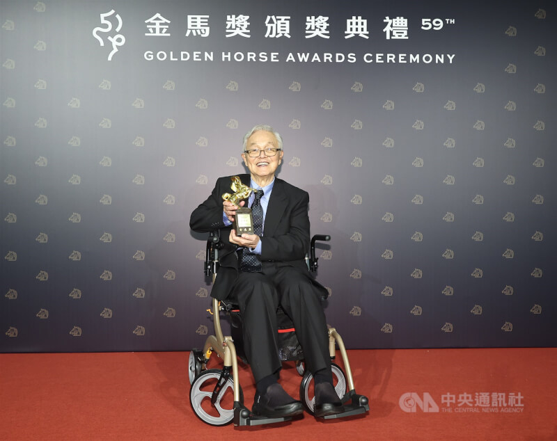 2022年賴成英獲頒第59屆金馬獎終身成就獎，他在後台與獎座合影留念。（中央社檔案照片）