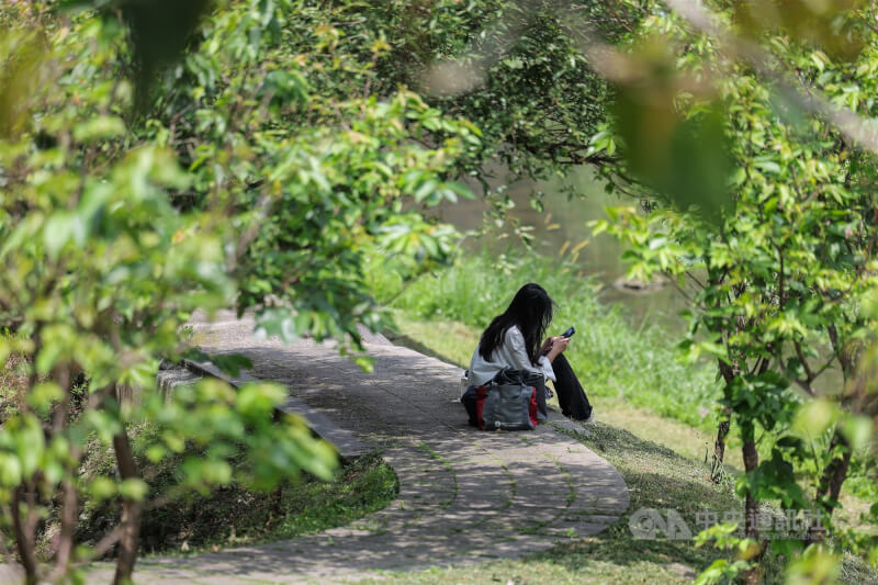 圖為台北市內湖區民眾於步道旁陰影處坐著休息。（中央社檔案照片）