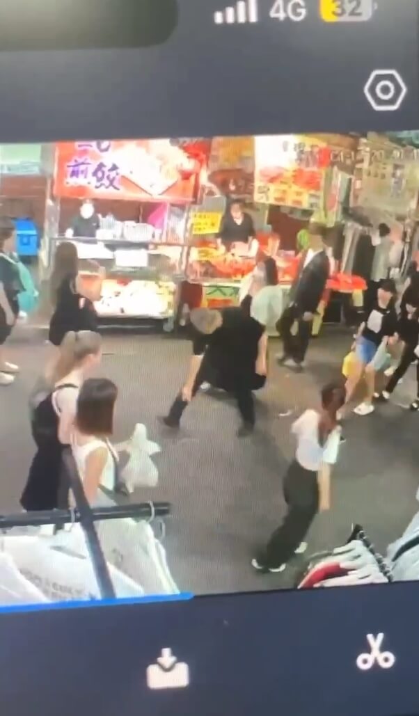 周俊銘（黑衣者）在執勤過程中曾朝地面及下方噴灑辣椒水。（台中市政府警察局提供）