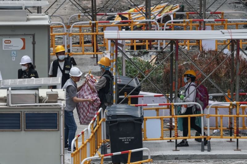 香港宏福苑居民20日返回住家收拾物品。（路透社）