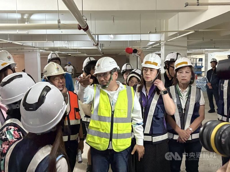 新北市長侯友宜（中）21日視察板橋信義國小地下停車場工程，交通局長鍾鳴時（左，橘背心）陪同講解工程進度。中央社記者曹亞沿攝　115年4月21日