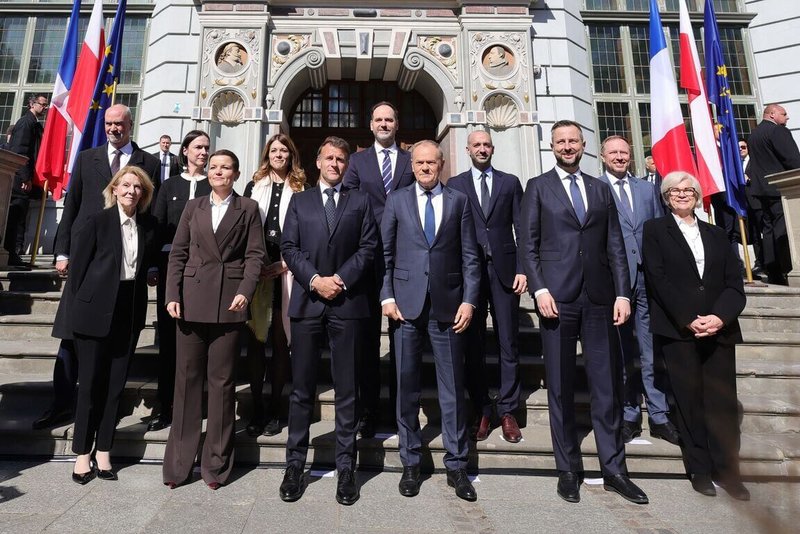 法國總統馬克宏（前左3）、波蘭總理圖斯克（前右3）及兩國代表團於格但斯克長廣場（Długi Targ）上著名的亞瑟廷（Dwór Artusa）門前踏階留下紀念合照。（波蘭總理府提供）中央社記者鄭淨伃華沙傳真　115年4月21日