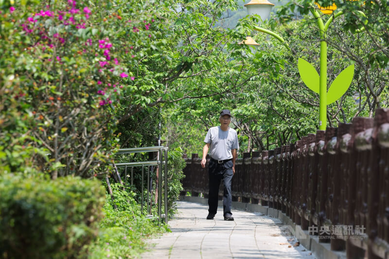 圖為台北市內湖區民眾一早戴著帽子外出散步。（中央社檔案照片）