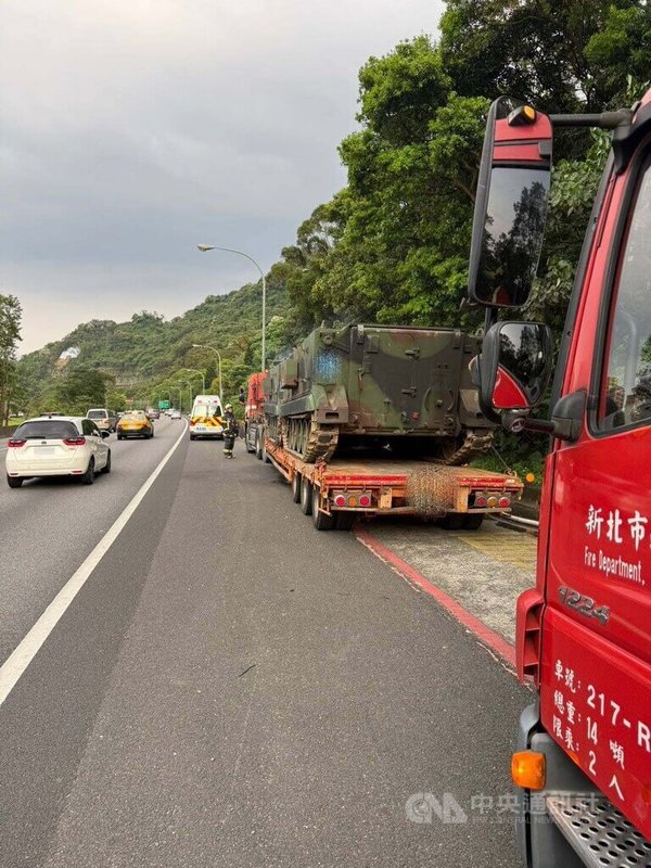 一輛載運裝甲車的拖板車21日中午行經國道3號苗栗路段時起火，延燒至裝甲車，撲滅火勢換車後續北上。下午行經安坑路段時換裝甲車冒煙，消防隊到場灑水降溫。（翻攝畫面）中央社記者曹亞沿傳真　115年4月21日
